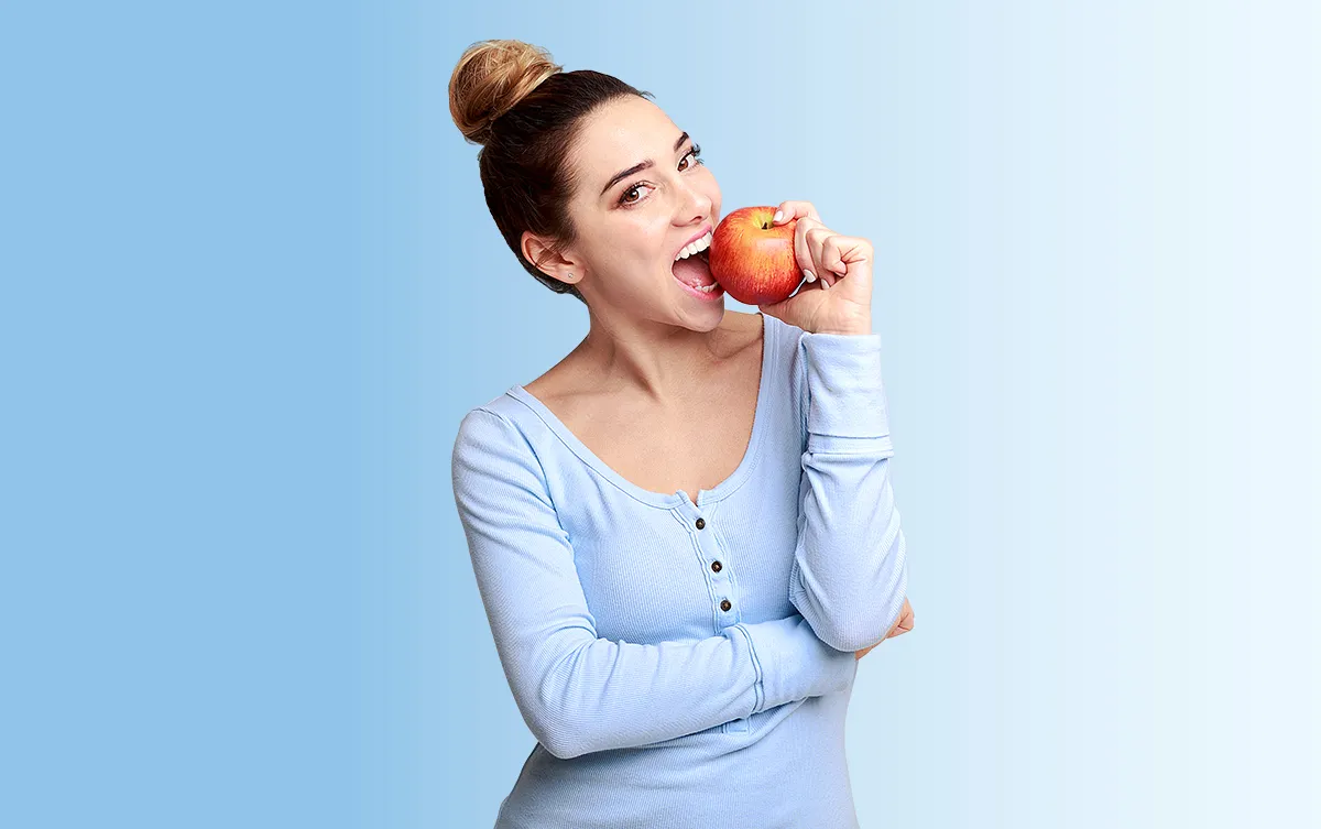 Vit-D3-Galen Slider Ebene 11 Eine weibliche Person beißt in einen Apfel