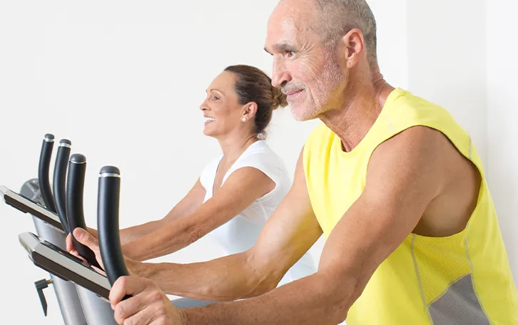 Eine ältere weibliche und männliche Person auf Ergometer