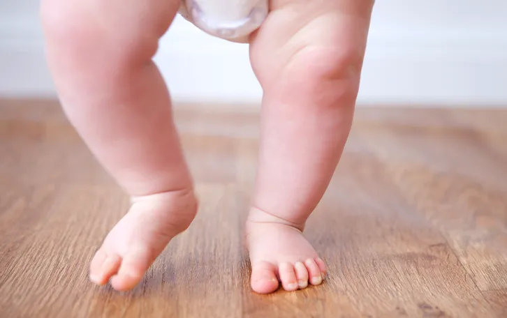 Von einem laufenden Baby die Beine sind frontal zu sehen