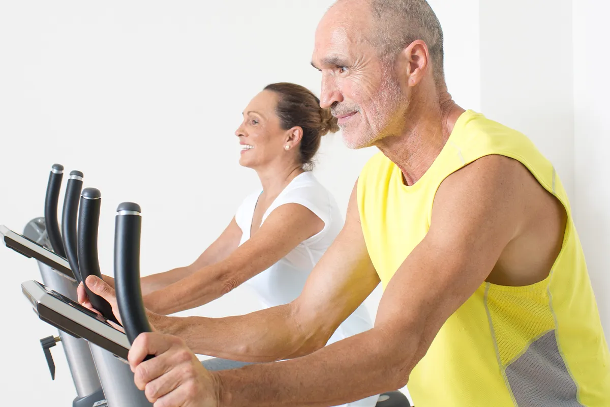 vit-d3-fuer-herz-kreislauf-gesundheit-vitamin-d Eine ältere weibliche und männliche Person auf Ergometern