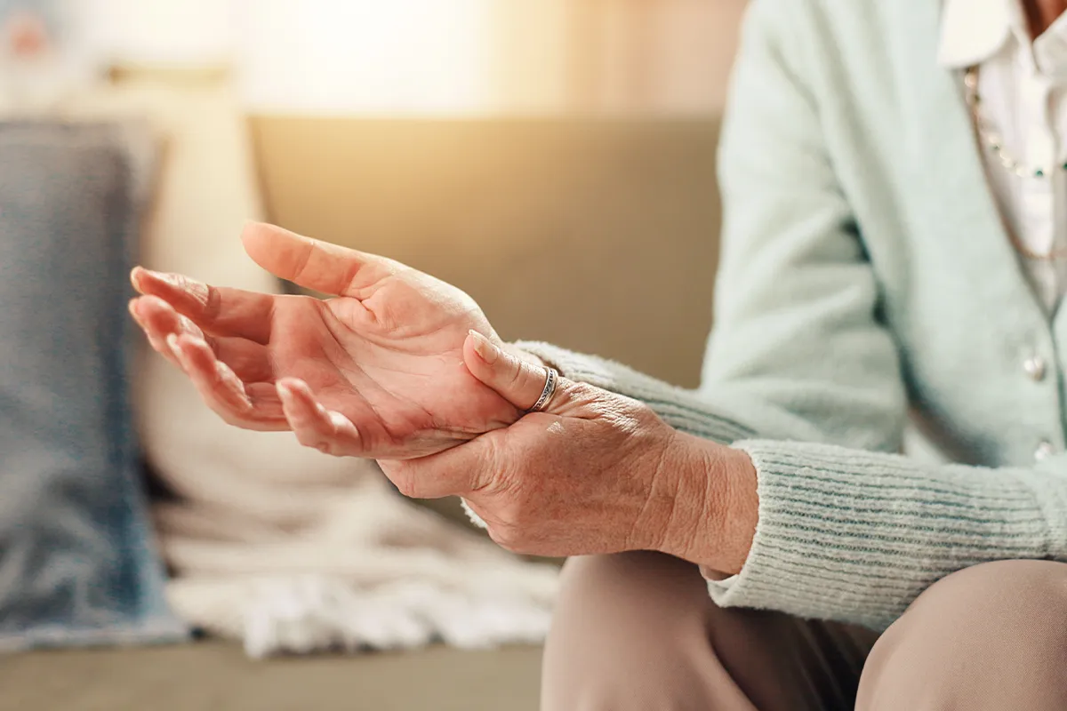 Vitamin D Mangel und Auswirkungen Eine ältere weibliche Person reibt sich das Handgelenk